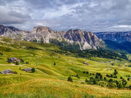 Golvende alpenweiden met almhutten en de dolomietkam erachter – Rondje over de Monte Seceda, Val Gardena